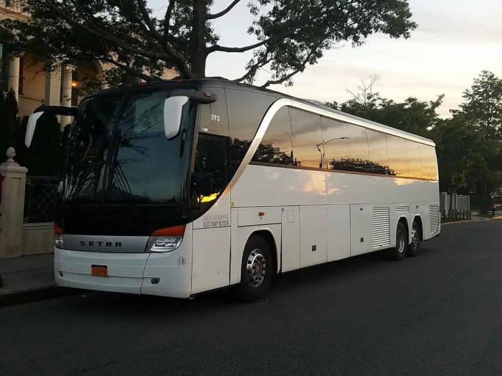 White 50 passenger party bus parked in a lot