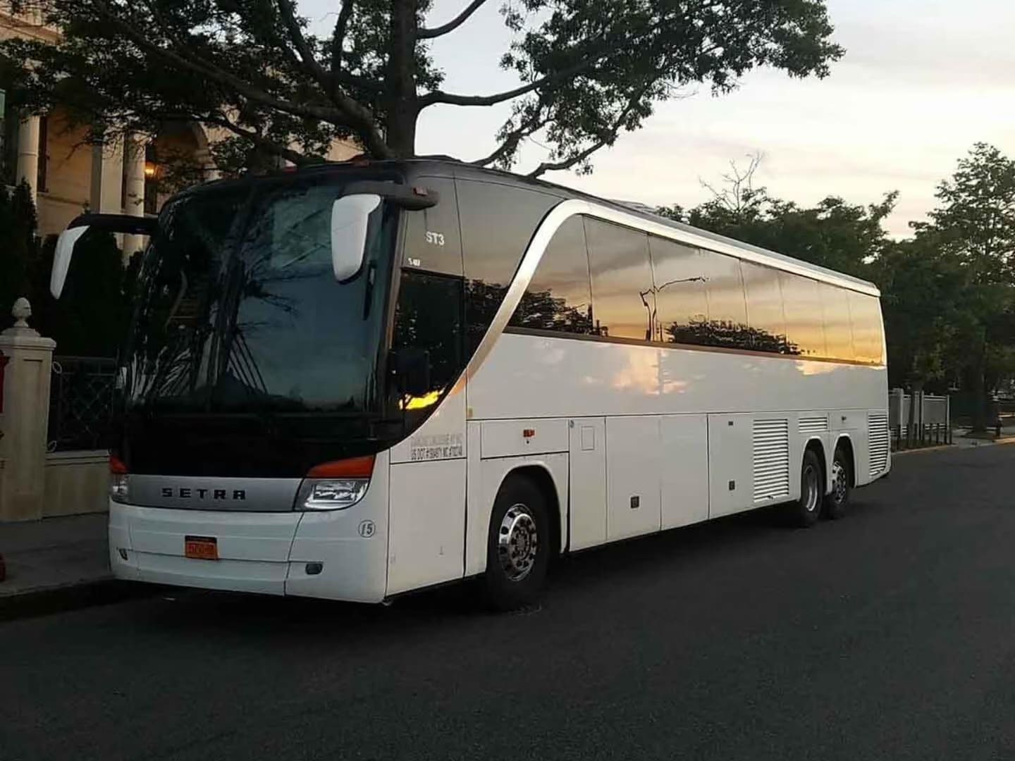 White 50 passenger party bus parked in a lot