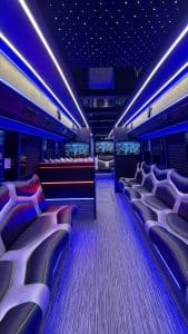 50 passenger party bus interior in blue with starlight ceiling, lit bar, and two-tone leather lounge seating