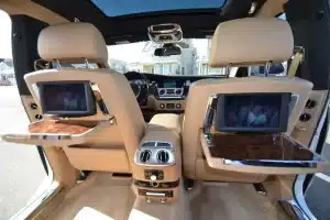 Rolls-Royce Ghost rear cabin with twin entertainment screens, picnic tables, and panoramic roof