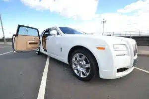 Front three-quarter view of a white Rolls-Royce Ghost with the coach door open