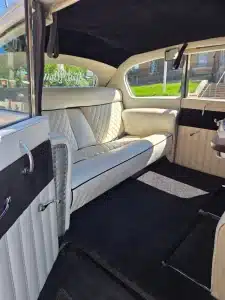 Cream quilted leather bench seat inside the 1953 Rolls-Royce classic wedding car, with a Just Married decal on the rear window