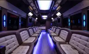 Interior of the 35 passenger party bus with wraparound leather seating, hardwood floor and blue LED party lighting