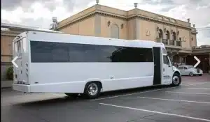 Exterior of the white 35 passenger party bus parked outside a catering venue